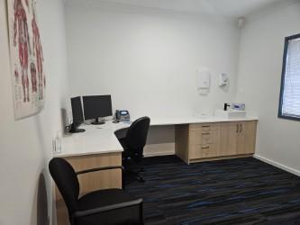 Consulting room with desk, sink and anatomy chart